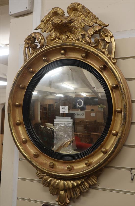 A Regency giltwod and gesso convex wall mirror, with eagle pediment H.96cm